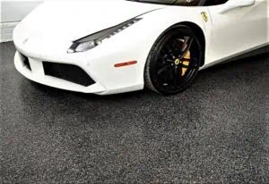 White sports car on a gray, full-flake epoxy and polyaspartic coated garage floor.